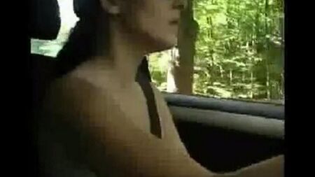 Mujer desnuda conduciendo un coche