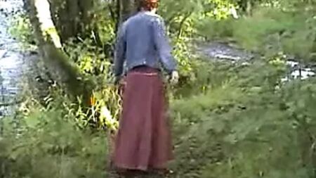 Una mujer madura y exhibicionista se masturba junto al río