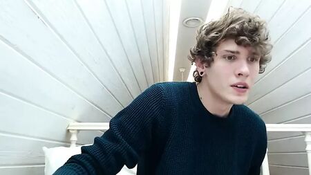 Un chico guapo con el pelo rizado se corre