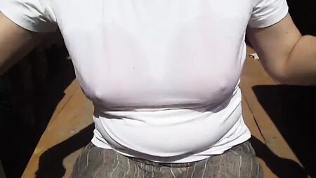 Una chica se quita el sujetador de baño mojado que lleva debajo de la camiseta mojada