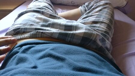 Un chico guapo y joven nos tienta mostrando su pene bajo el pantalón de pijama a cuadros