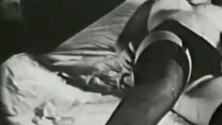 Chica en la cama con medias negras sensuales (vintage de los años 60)