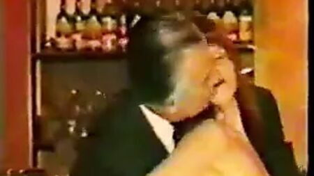 Hombres mayores en traje son objeto de bromas por parte de una camarera madura vestida de tweed