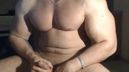 Un hombre muy guapo y musculoso posando y masturbándose
