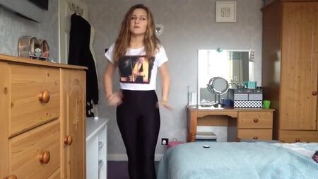 Una chica sexy se prueba unos leggings ajustados y brillantes de spandex
