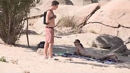 Un desconocido se queda prendado de la enorme polla de Jotade en la playa nudista