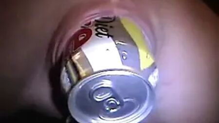 Coño dilatado y perforado con una lata de Coca-Cola dentro. Piercings corporales