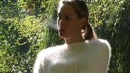 Una mujer con un jersey de punto ahuecado fuma