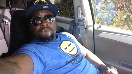 Un chico negro guapo se corre en la cara dentro del coche