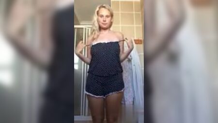 Una rubia de tetas grandes se desnuda en su cuarto de baño