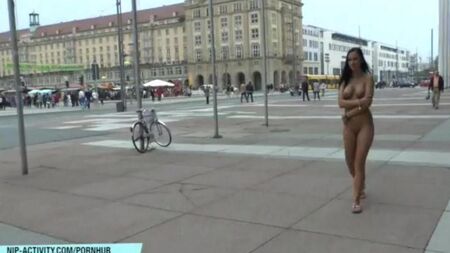 Chica desnuda camina por las calles de la ciudad
