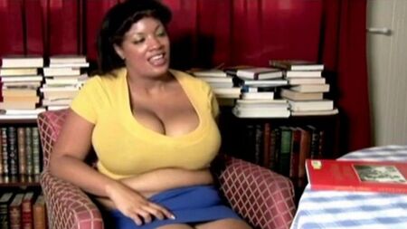 La mujer gorda Nigersh se sienta en una silla y quitándose las bragas de sus bragas