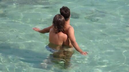 Chica tocando a un chico en el mar bajo el agua