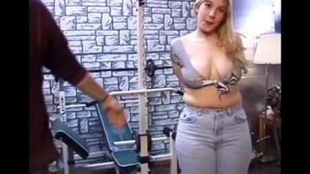 Una mujer de cabello largo con tetas naturales examina el pene de un hombre