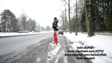 Una chica con botas rojas por encima de la rodilla y una chaqueta de plumón Moncler